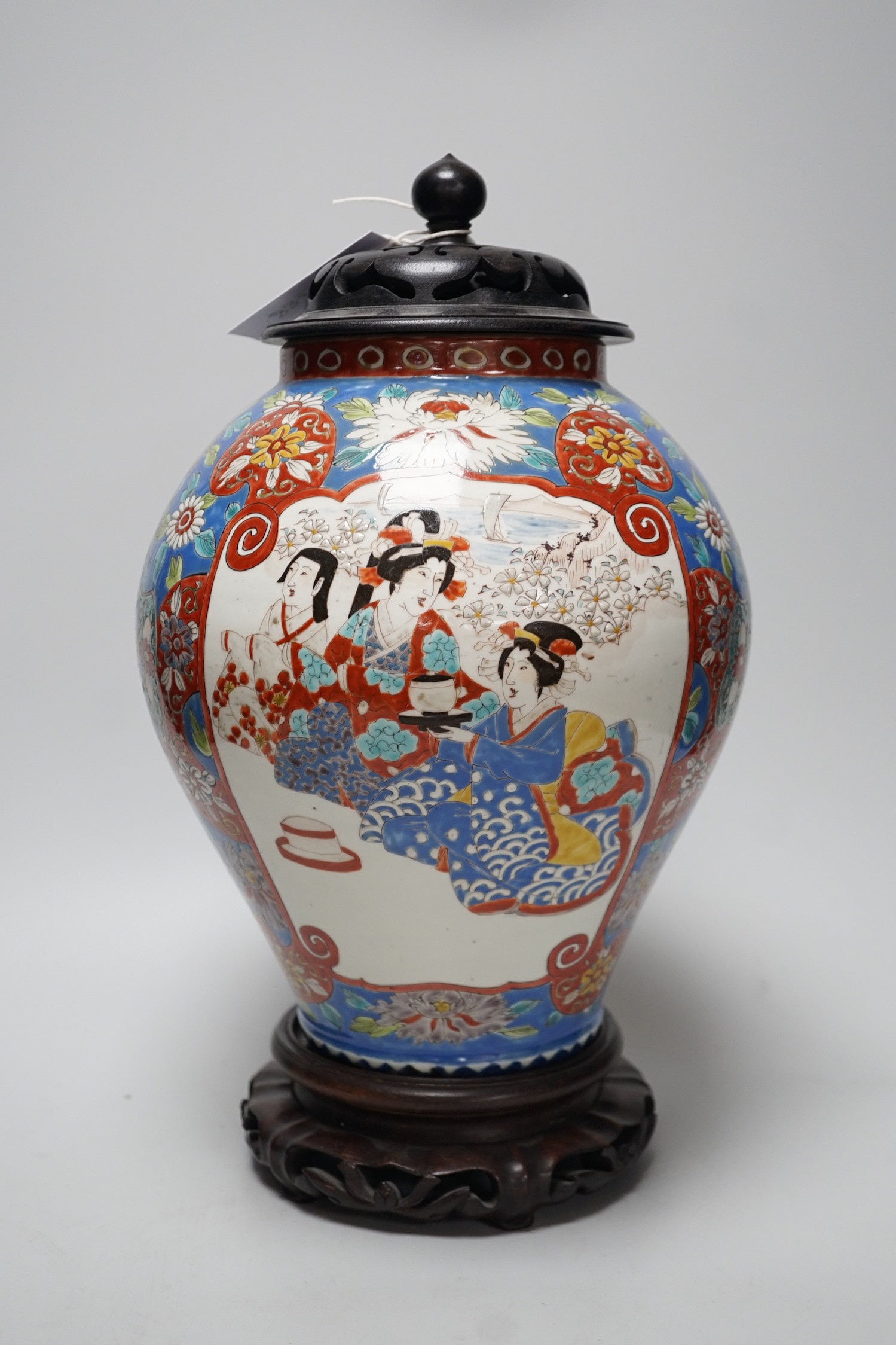 A large Japanese vase with carved wooden cover and base, 38cms high